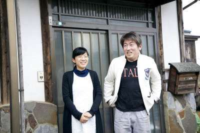 玄関の前に立っている、高橋さんご夫婦の写真